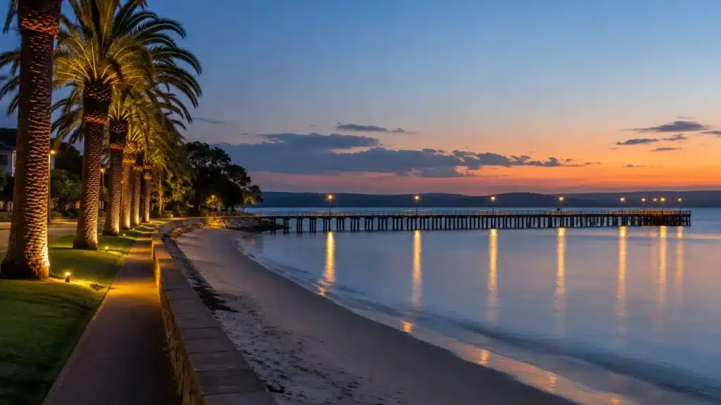 Palm-lined foreshore and a long timber pier at blue hour